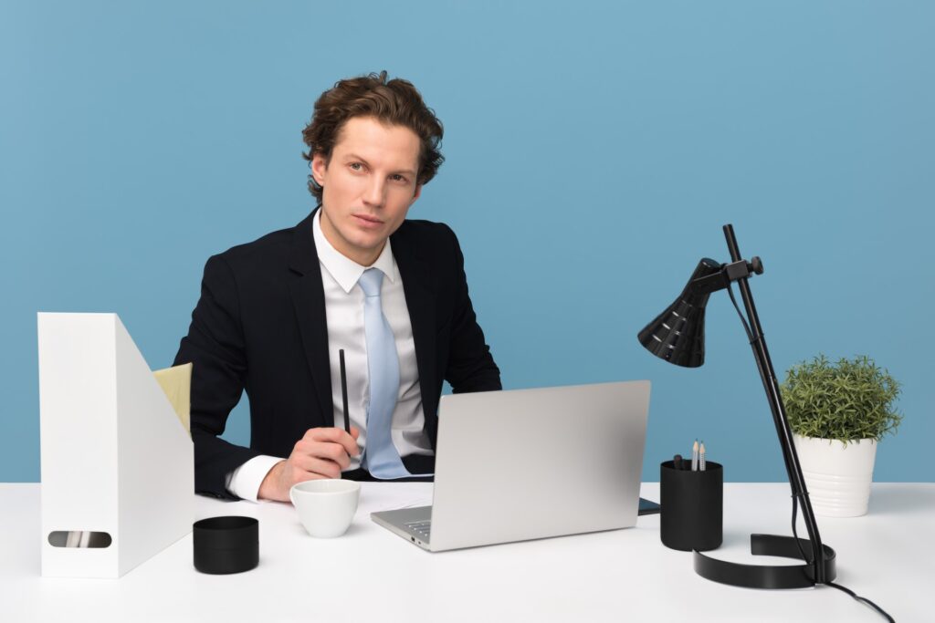 Professional-looking man in suit surrounded by office stuff