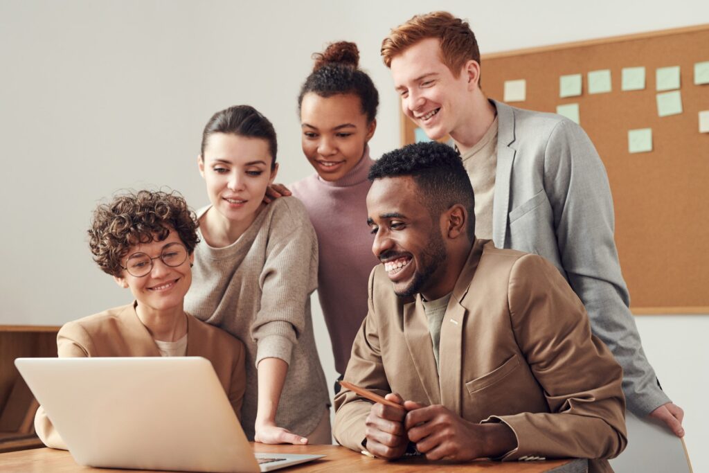 Group of people looking at a computer smiling